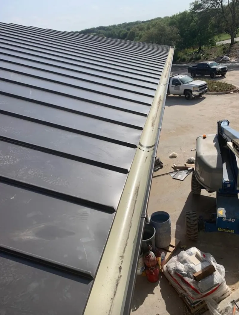 Standing seam panel and gutter detail on a metal roofing jobsite in Brewster